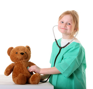 child playing with stethoscope and teddy bear
